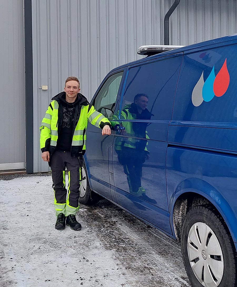 Mäntän Kaukolämpö ja Vesihuolto Oy:n työntekijä Samu Nikoskinen kunnallistekniikan asentaja seisoo pakettiauton vieressä.